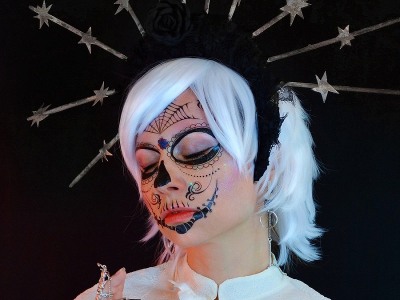 Eine junge Frau in einem Halloween-Kostüm, mit grauen Haaren.