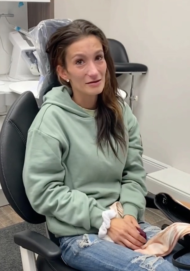 Eine Frau sitzt im Zahnarztstuhl