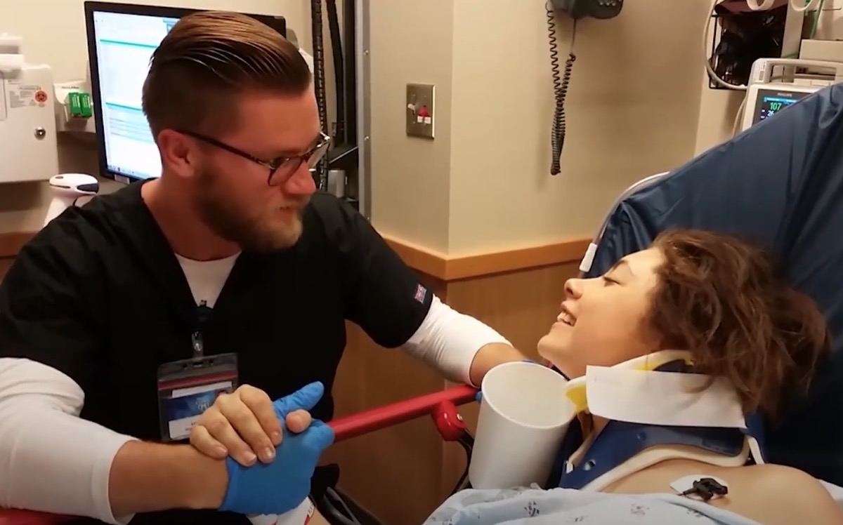 Ein Krankenpfleger tröstet eine betäubte Patientin im Krankenhaus