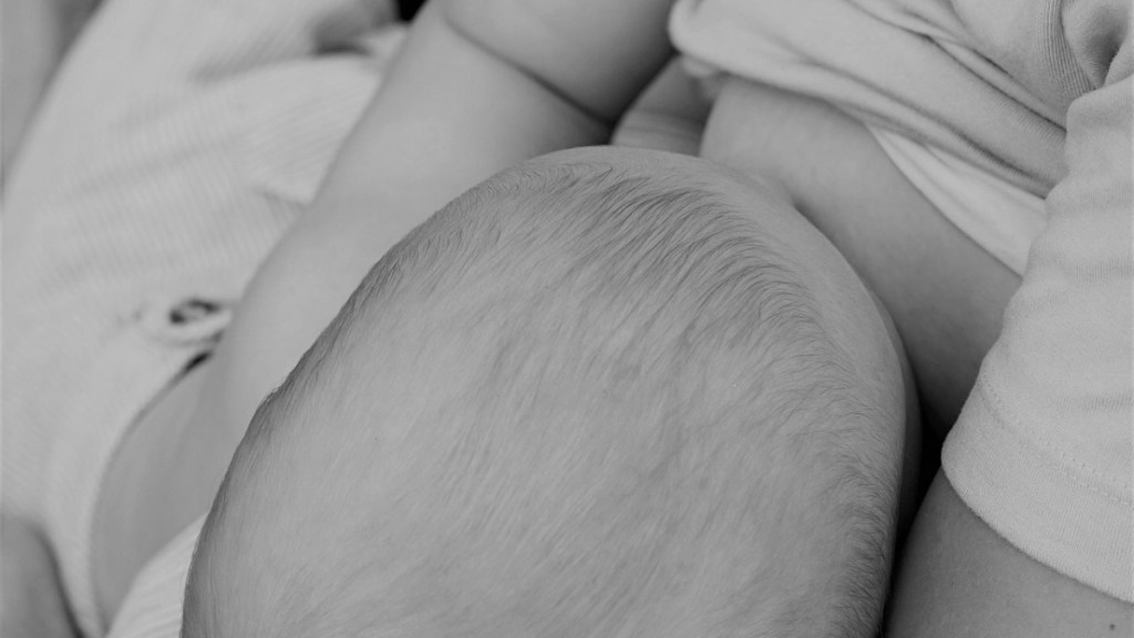 Ein Foto in Schwarzweiß von einer Frau, die ihr Baby stillt.