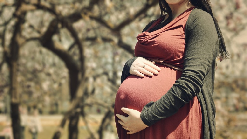 Eine Schwangere hält sich den Bauch.
