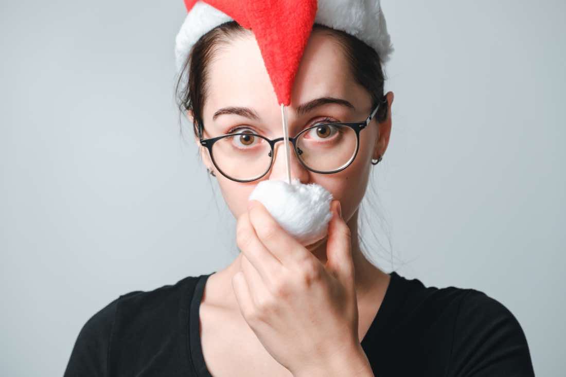 Ein Porträt einer verwirrten jungen Frau mit Weihnachtsmütze.