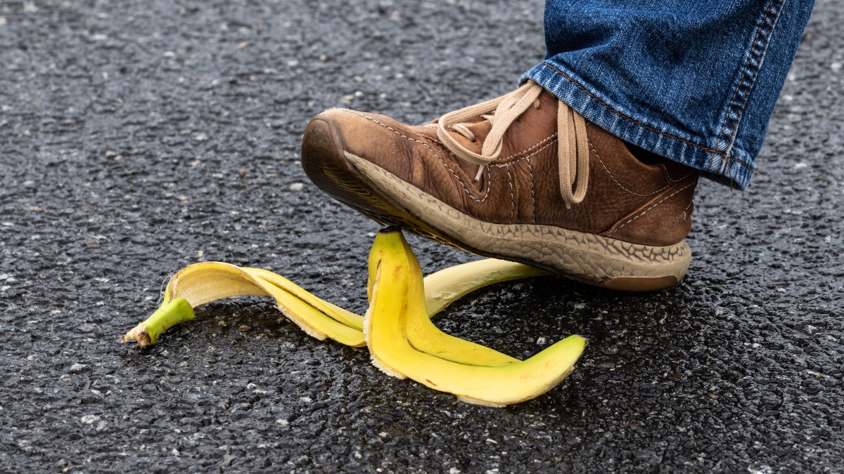 Ein Fußgänger tritt auf eine Bananenschale.