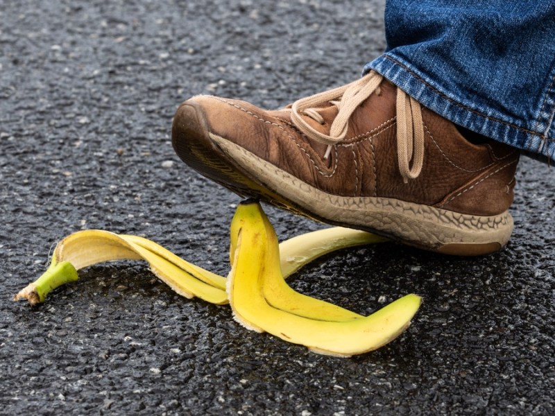Ein Fußgänger tritt auf eine Bananenschale.