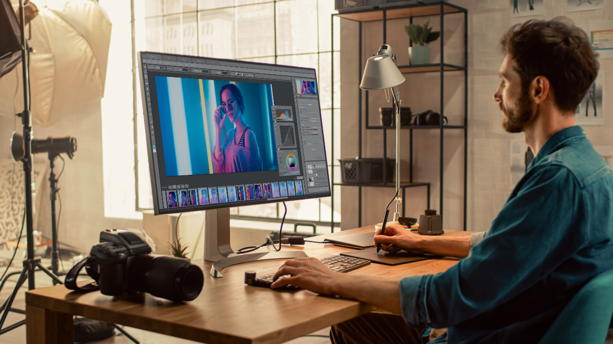 Ein junger Grafikdesigner bearbeitet ein Bild mit Photoshop am PC.