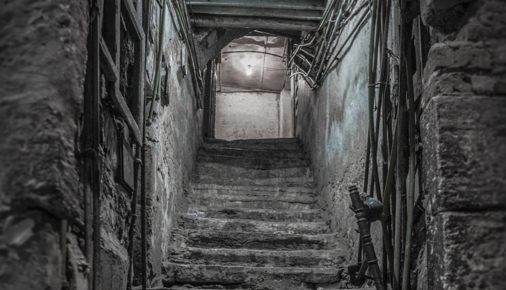 Ein Bild von einer dunklen Treppe, die in einen Keller führt.