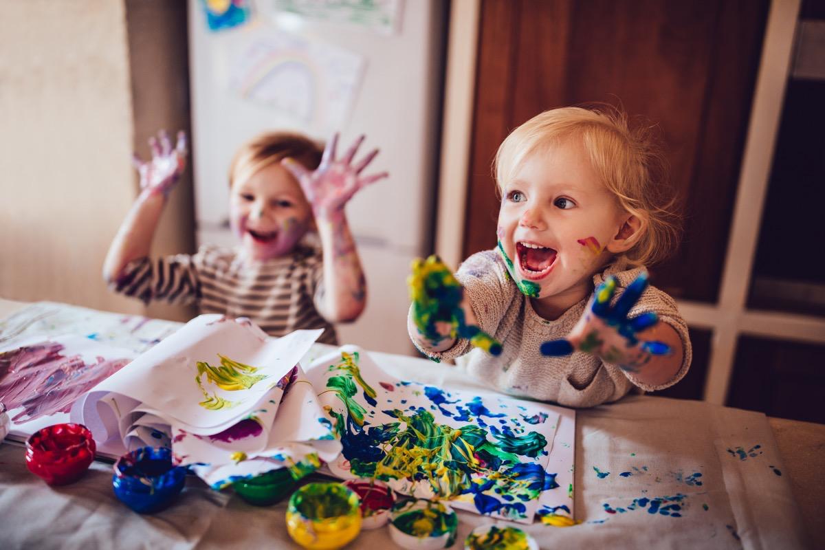 Zwei kleine Kinder malen mit Fingerfarbe