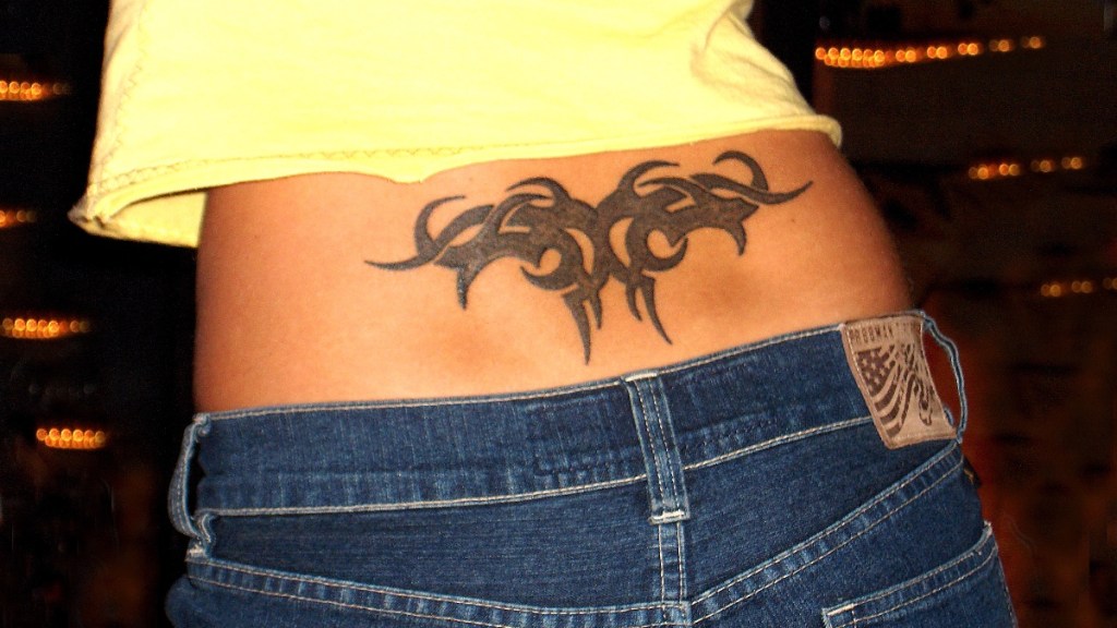 Ein Tribal-Tattoo auf dem unteren Rücken einer Frau.