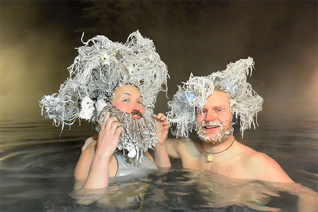 Eine Frau und ein Mann baden mit gefrorenen Haaren bei einem kanadischen Wettbewerb