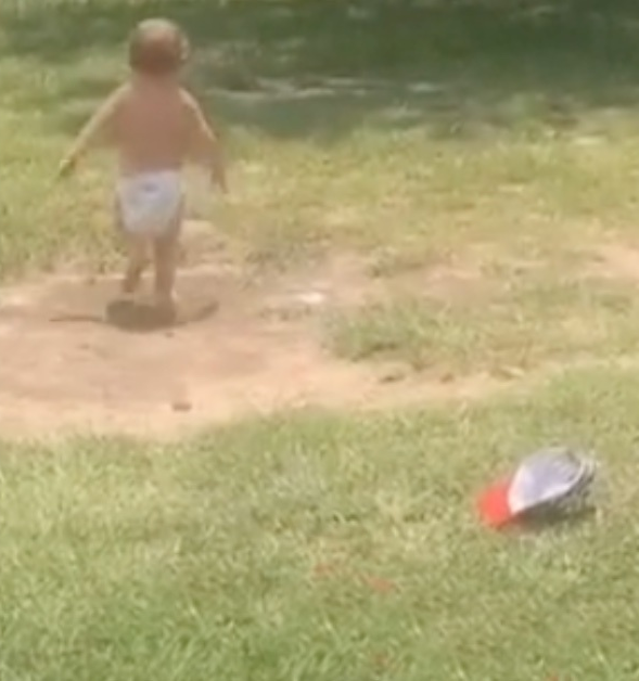 Das Kleinkind läuft weiter, seine Mütze liegt im Gras