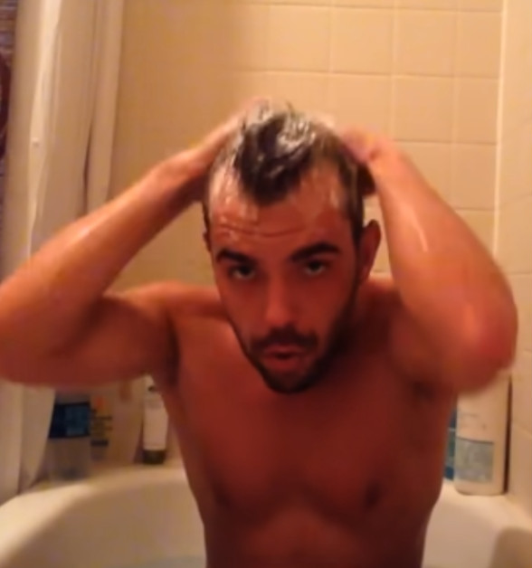 Alain Bruno sitzt in der Badewanne und wäscht sich die Haare