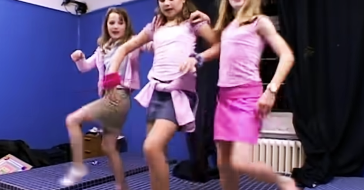 Drei junge Mädchen, die in einer Reihe tanzen.