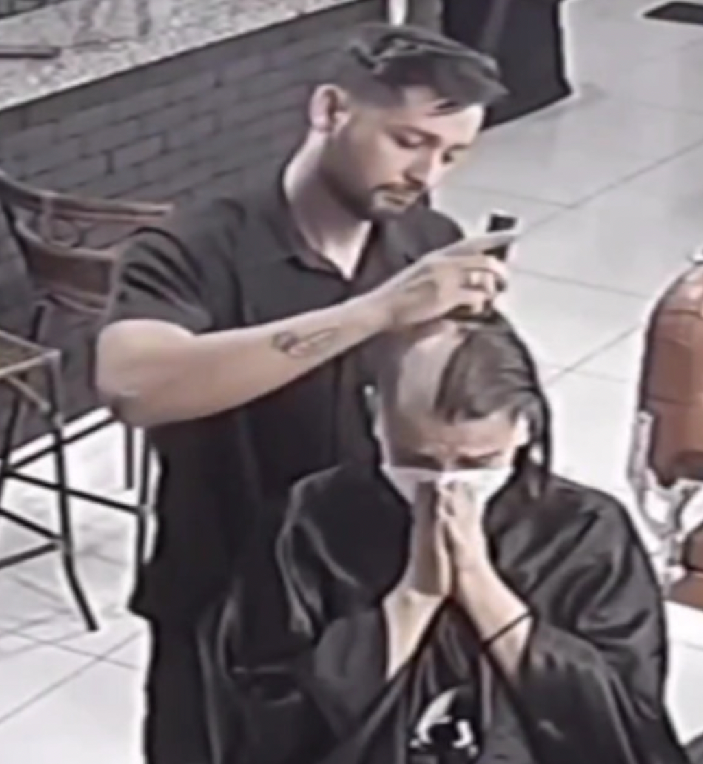 Ein Friseur beginnt damit, den Kopf einer weinenden Frau kahlzurasieren