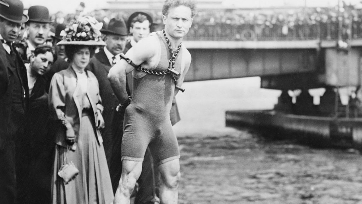 Ein Schwarzweiß-Foto vom gefesselten Harry Houdini vor seinem Sprung in den Charles River, 1904.