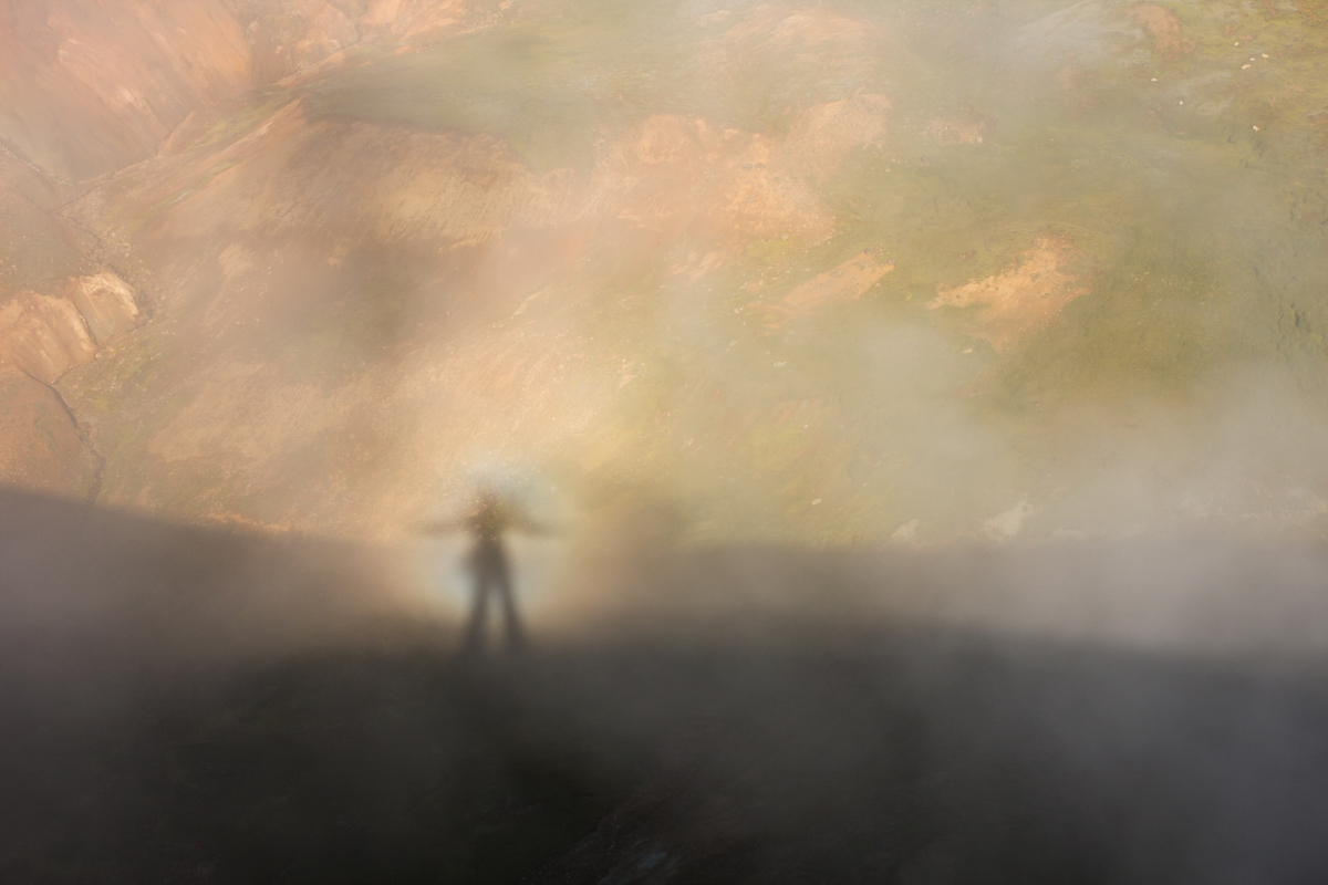 Ein Bild von einer Geistererscheinung, einem sogenannten 'Brockengespenst' im Nebel auf einem Berg.