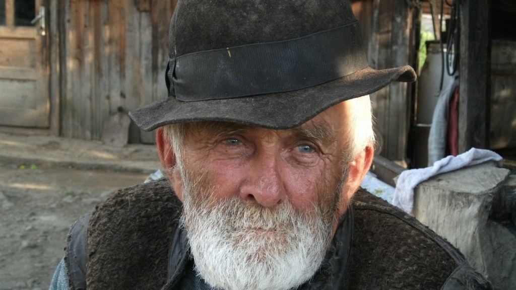 Ein Bild von einem alten Bauern mit Hut.