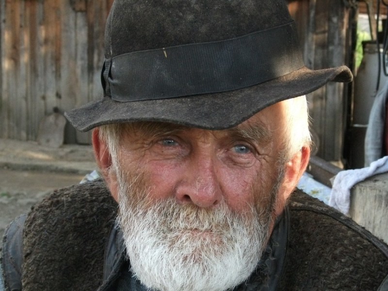 Ein Bild von einem alten Bauern mit Hut.