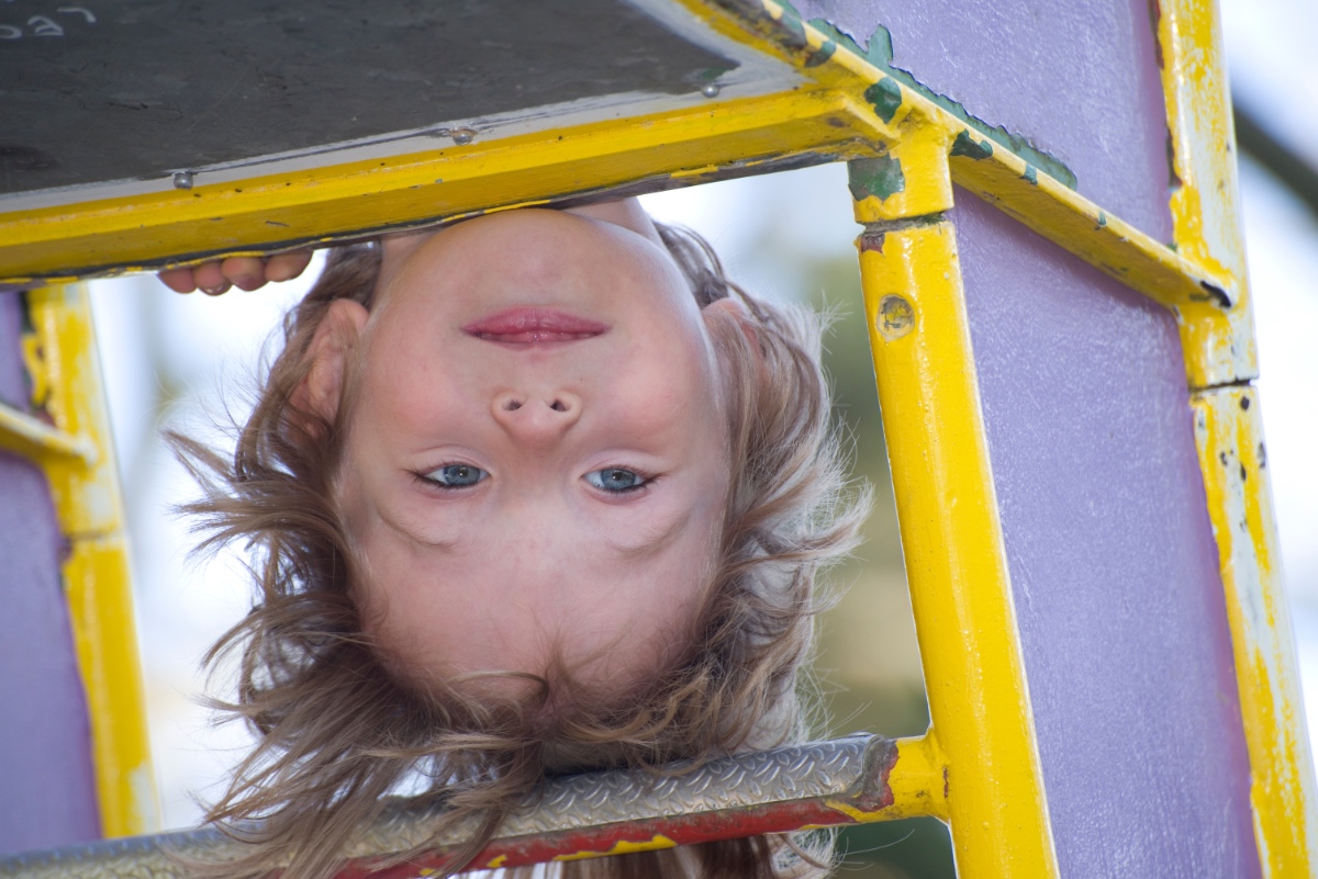 Ein Kind spielt auf einem Klettergerüst auf einem Spielplatz.
