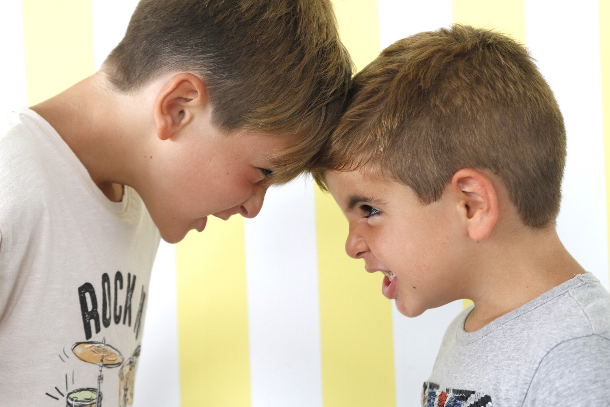 Zwei Kinder streiten und stecken die Köpfe zusammen.