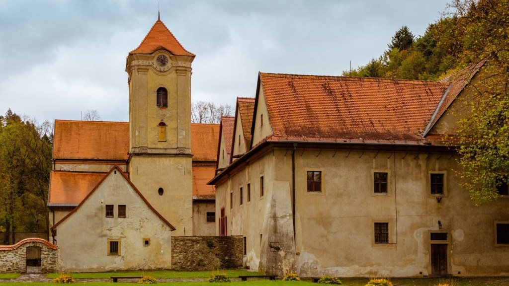 Ein Bild von einem Kloster in einem Wald.