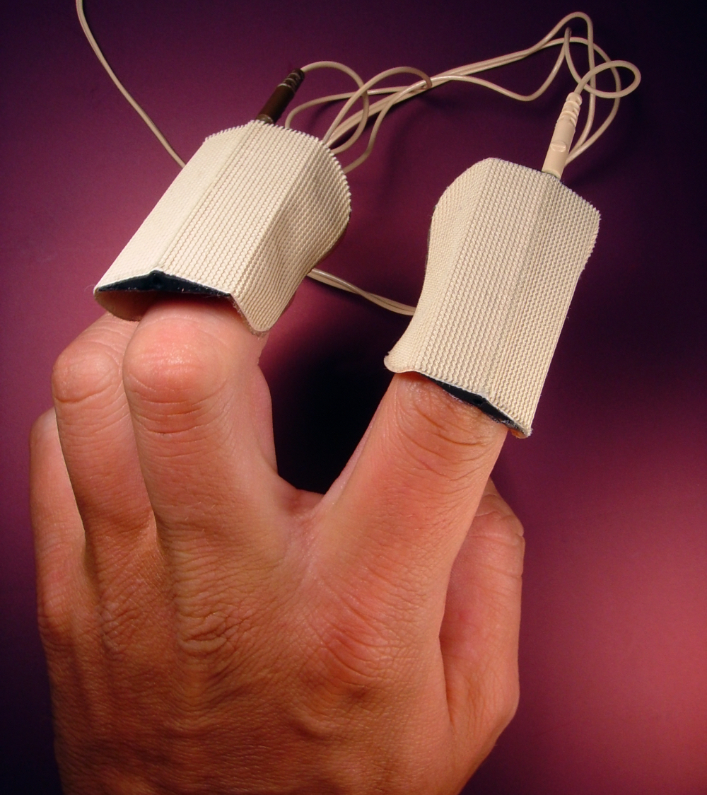 Eine Hand, die mit Elektroden von einem Lügendetektor verbunden ist.