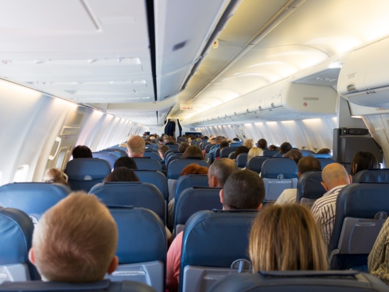 Das Innere eines Flugzeugs mit Passagieren, die darauf warten, dass die Maschine startet.