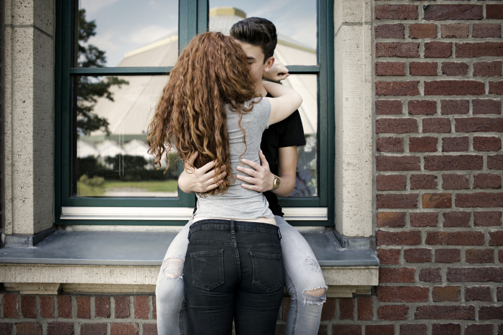 Zwei Teenager umarmen und küssen sich.
