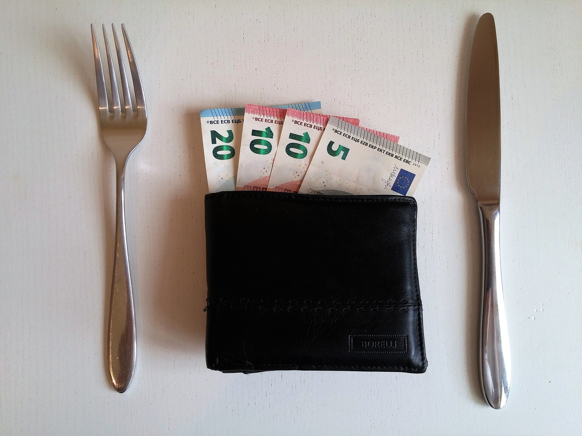 Geld und Messer und Gabel.
