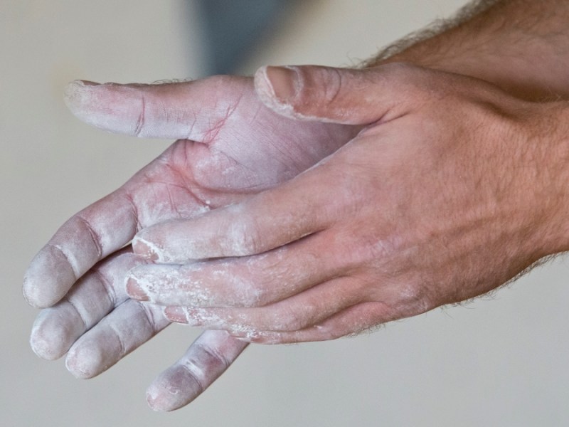 Ein Mann reibt sich die Hände mit Kreidepulver ein.