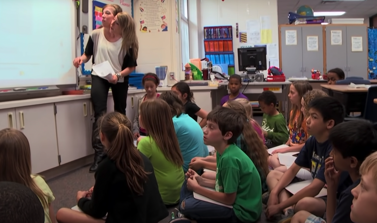 Siamesische Zwillinge im Klassenzimmer unterrichten Grundschüler