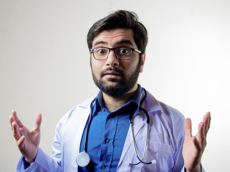 Ein Arzt mit Stethoskop und weißem Kittel.