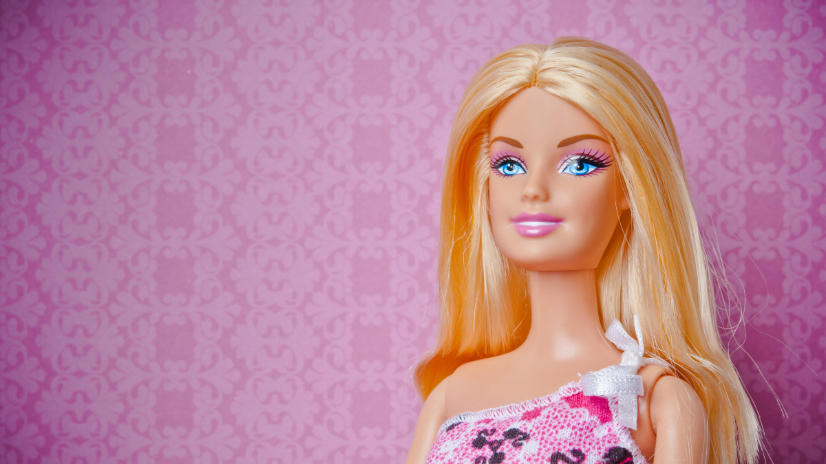 Eine blonde Barbie-Puppe vor einem pinken Hintergrund