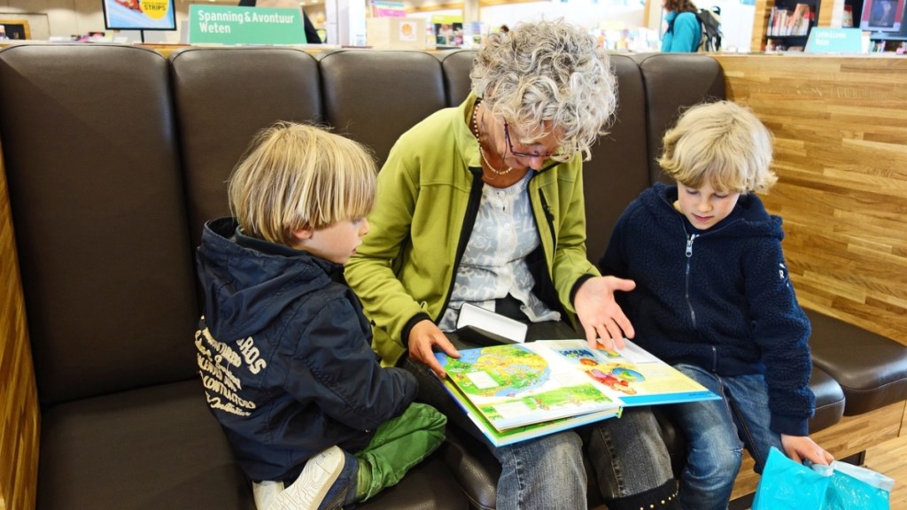 Eine Großmutter liest ihren Enkeln eine Geschichte vor.