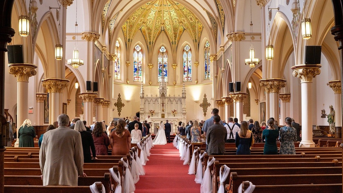 Ein Hochzeitspaar steht in einer Kirche vor dem Altar.