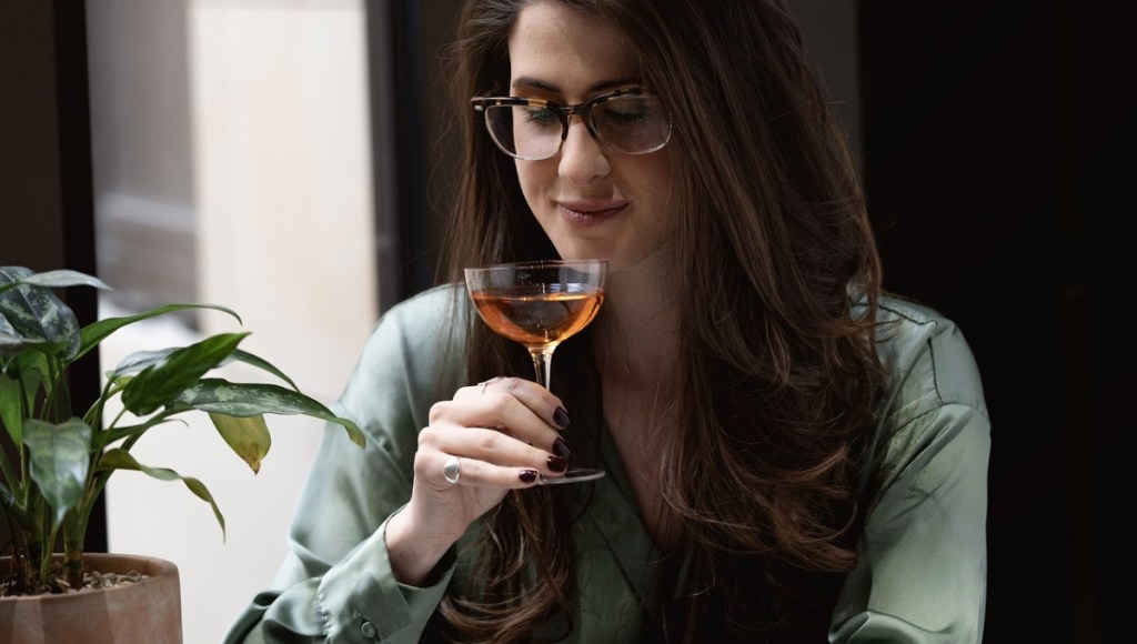Eine Frau trinkt einen Cocktail.