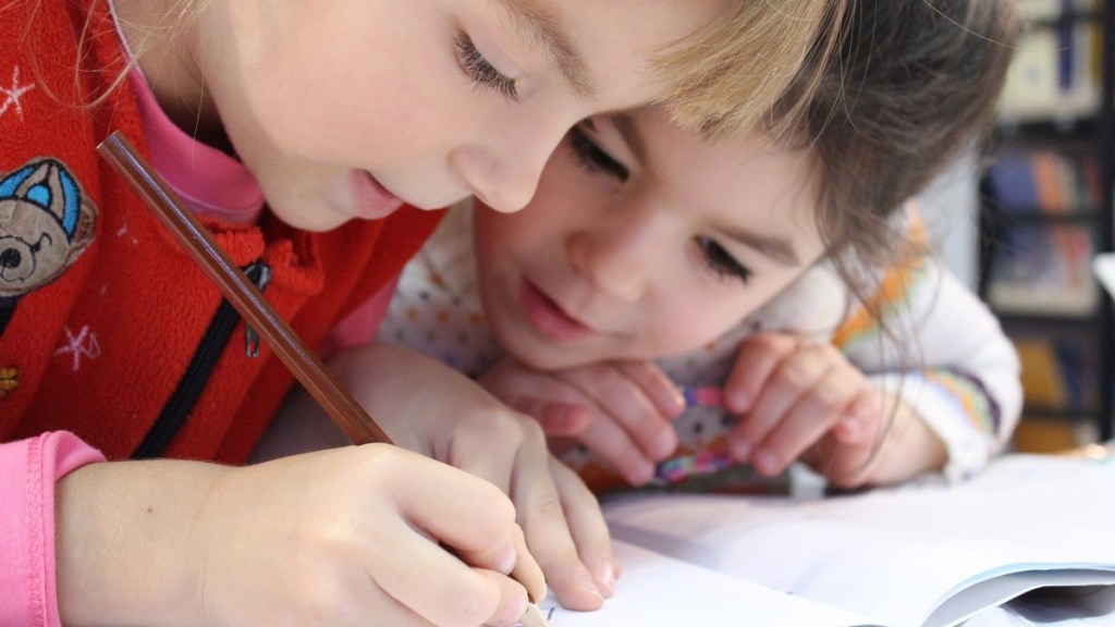 Zwei kleine Mädchen schreiben in ihrem Schulfheft.