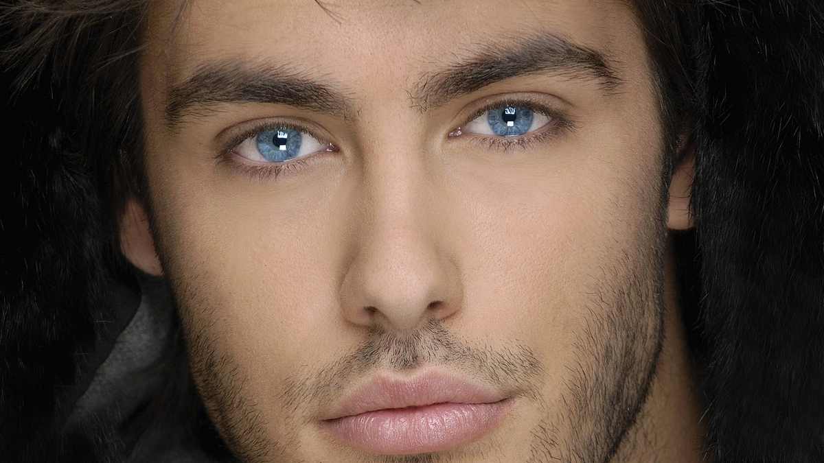 Ein Porträt von einem männlichen Model mit blauen Augen.