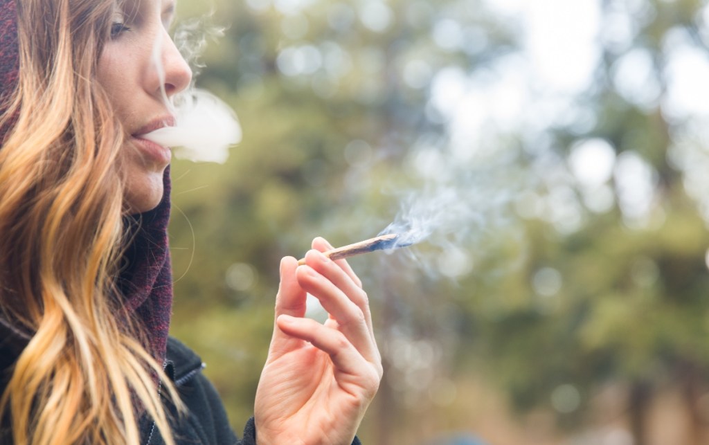 Frau raucht Cannabis Joint.