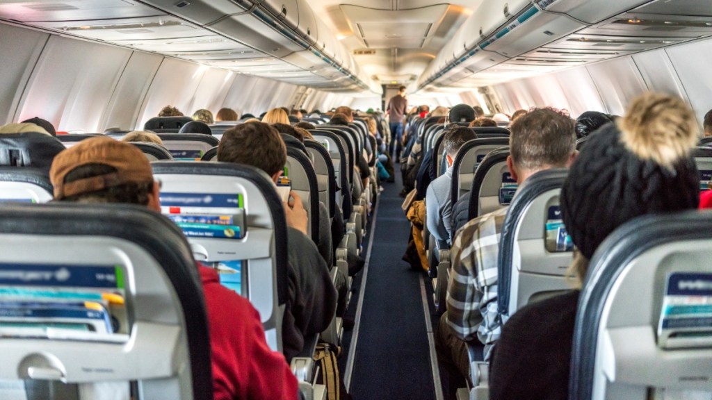 Passagiere in einem kommerziellen Passagierflugzeug sitzend.