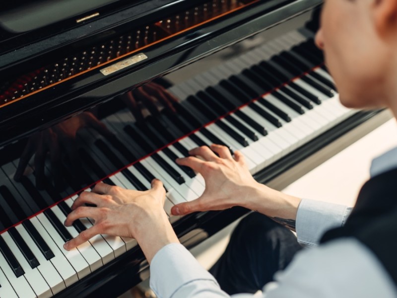 Pianist spielt Musik auf einem Flügel.