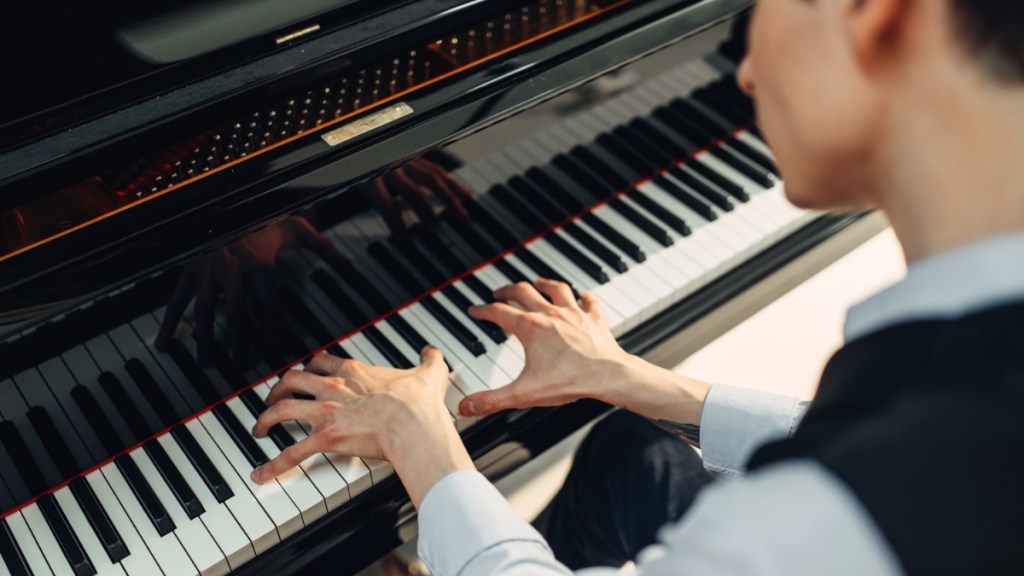 Pianist spielt Musik auf einem Flügel.