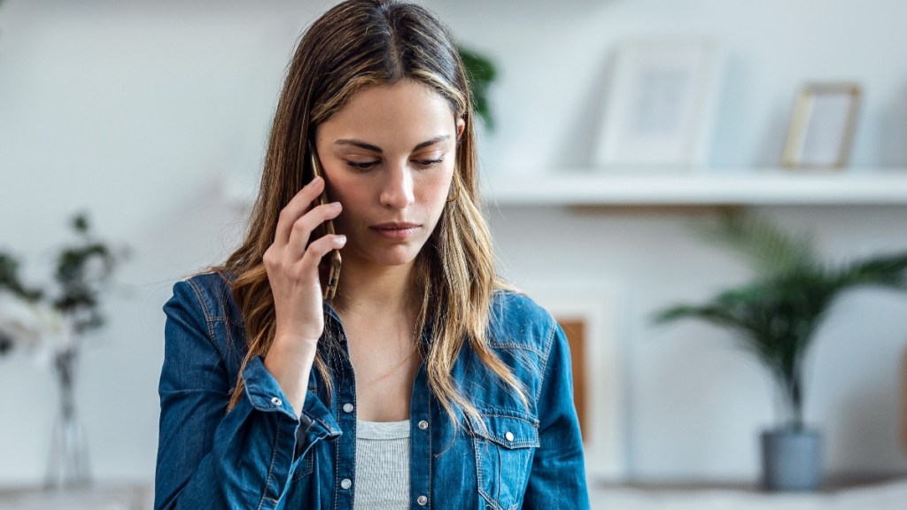 Schöne junge Frau telefoniert zu Hause.