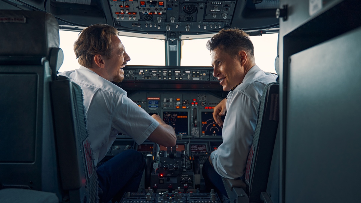 Zwei Piloten im Cockpit, die lachen.
