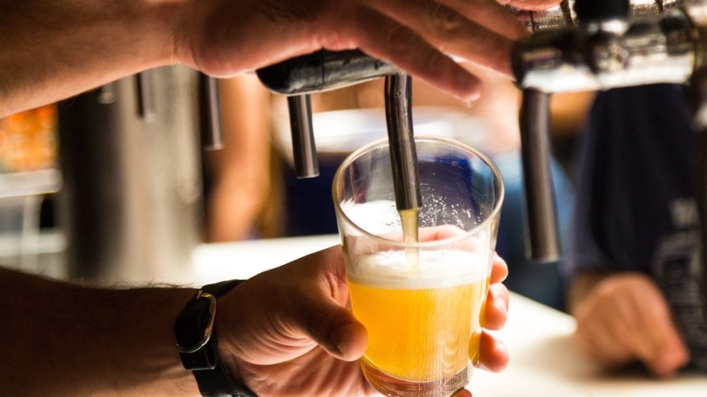 Ein Bier wird in ein Glas gezapft.