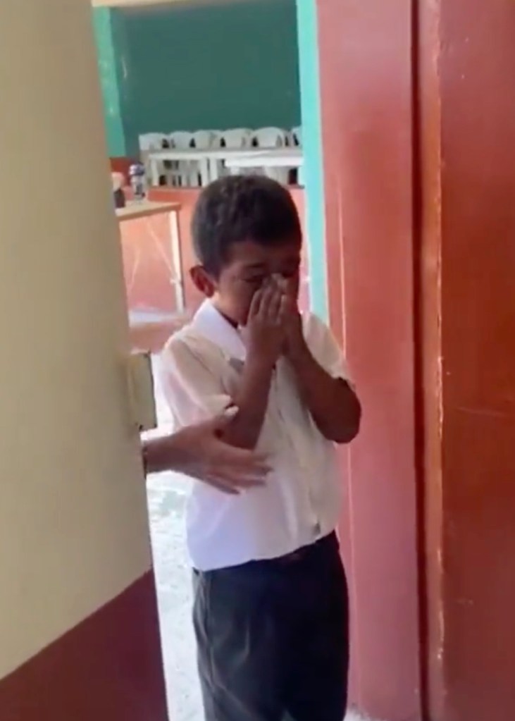 Ein Junge steht weinend in der Tür zu einem Klassenzimmer.