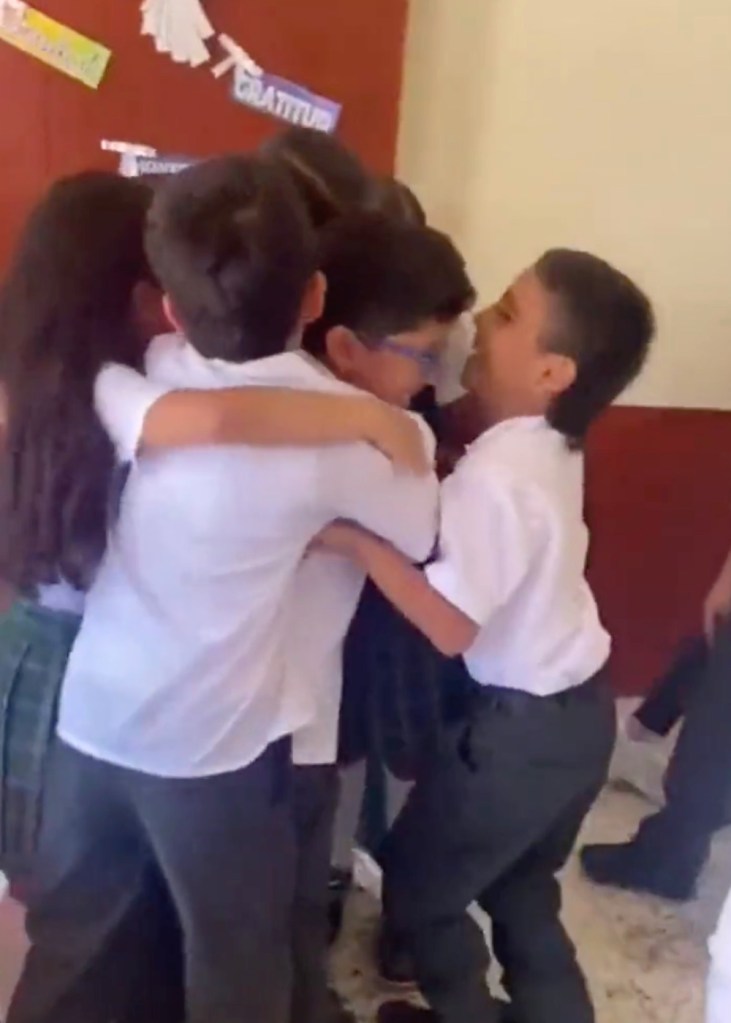 Ein Junge wird von seinen Mitschülern umarmt.