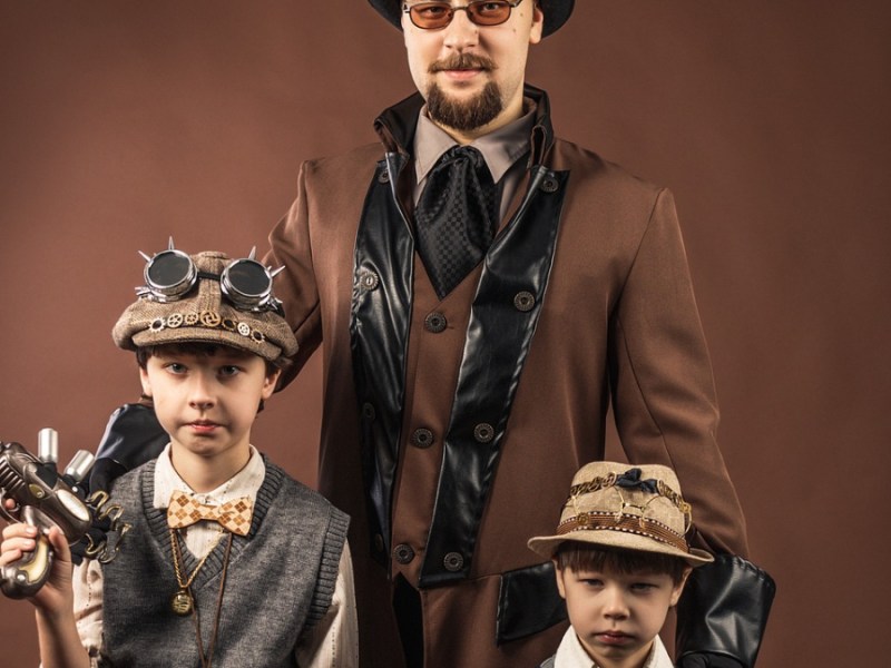 Ein Vater mit seinen Kindern, die an Halloween Steampunk-Kostüme tragen.