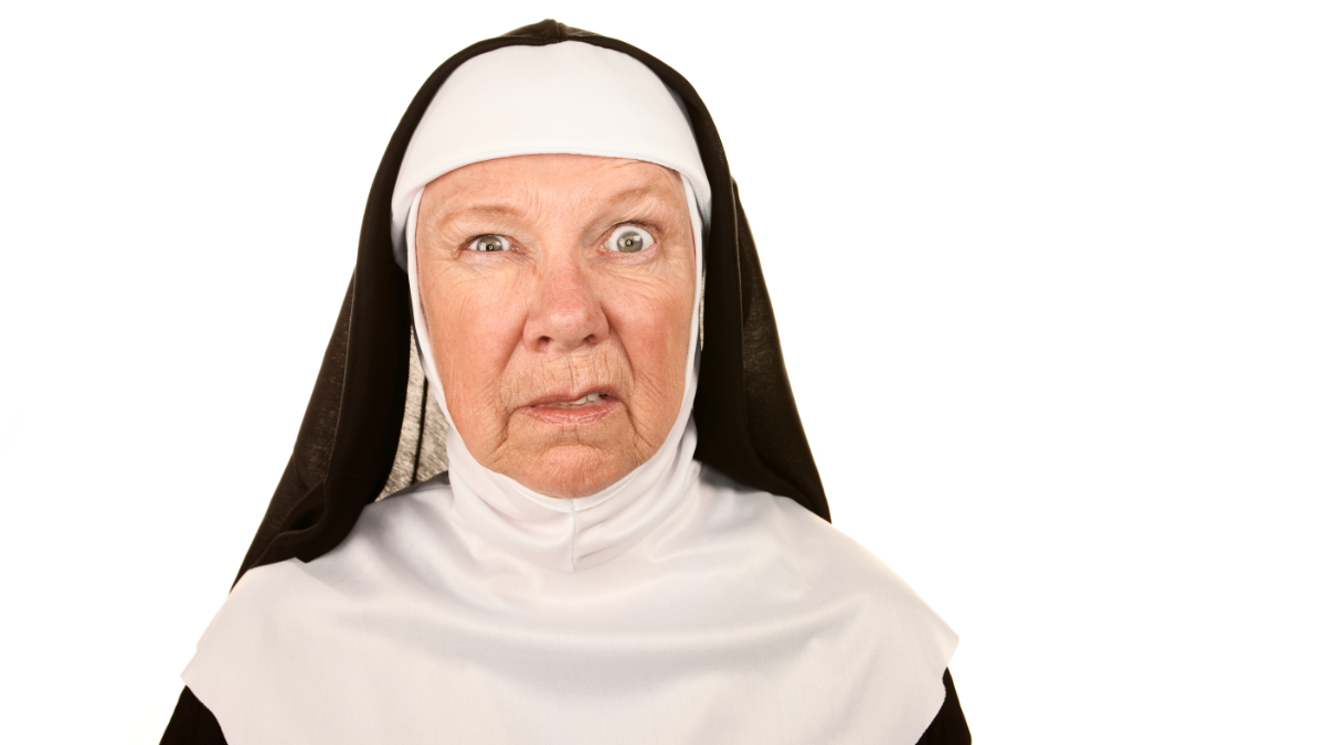 Eine ältere Nonne, die eine witzige Grimasse zieht, vor einem weißen Hintergrund