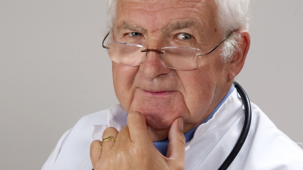 Ein Bild von einem älteren Arzt mit Brille und Stethoskop.