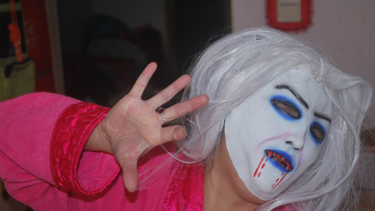 Eine Frau mit einer Halloween-Hexen-Maske.